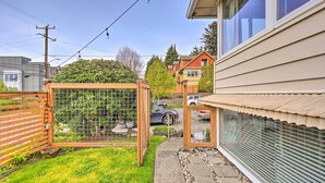 A residential backyard with a fenced garden, a pathway, and a house with a garage. - Seattle Garden Retreat: Walk to Water & Shops! (Seattle)