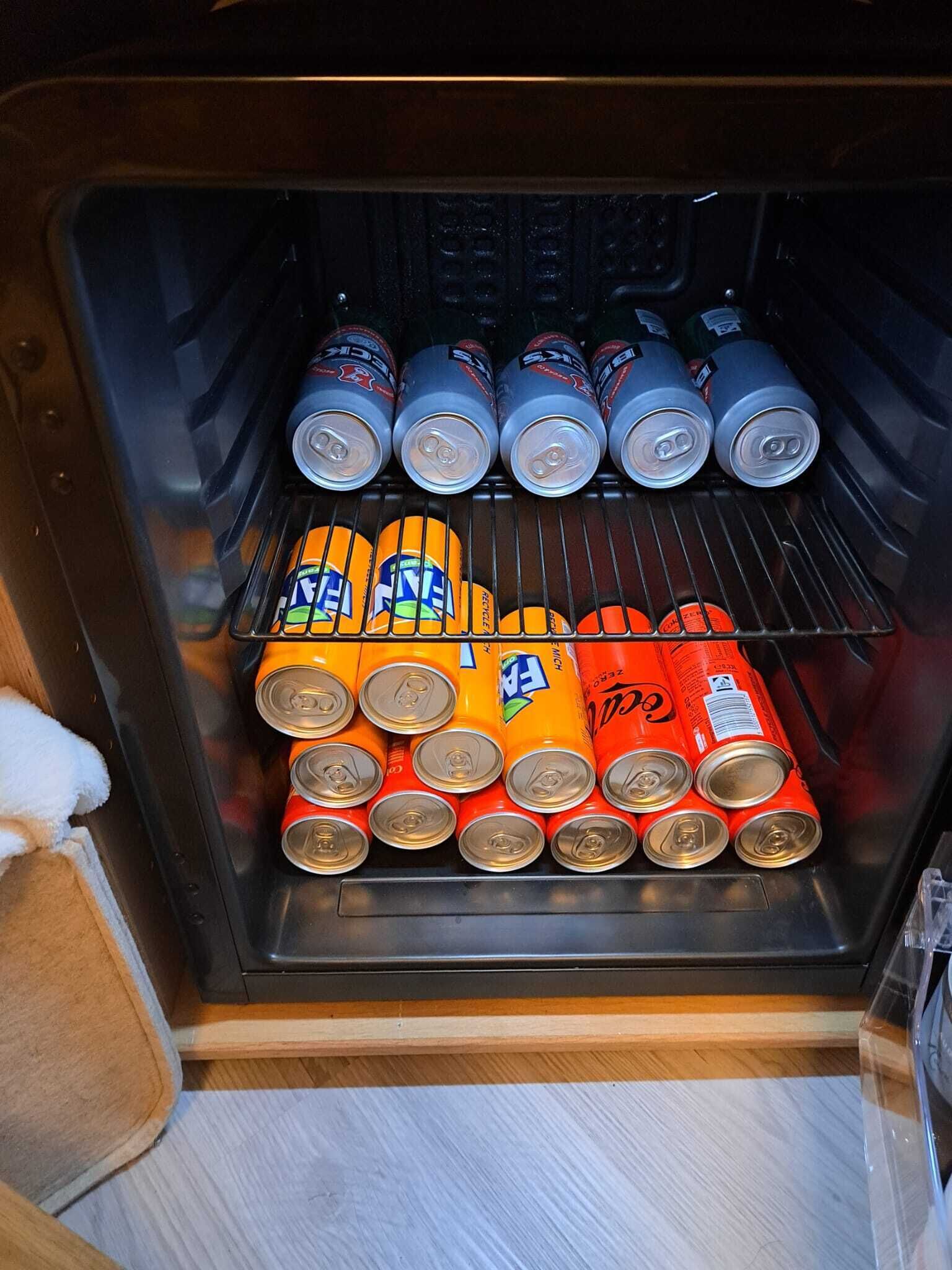 Máquina expendedora con varias latas de bebidas.