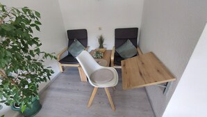 A small, enclosed balcony with two chairs, a table, and a potted plant. - 5 km from the center, 1 km from the train station and 11 km from Baden-Airpark (Baden-Baden)
