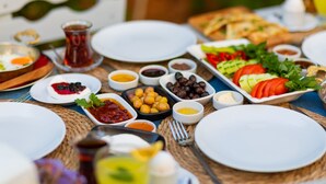 A table set with various dishes, including salads, olives, and dips, suggesting a meal setting. - Trend Cunda Otel (Ayvalik)