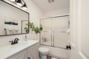 A bathroom with a white vanity, a large mirror, a shower enclosure, and a toilet. - Cascade Cabin, Walk to the Lake, Amazing Deck! (Cascade)