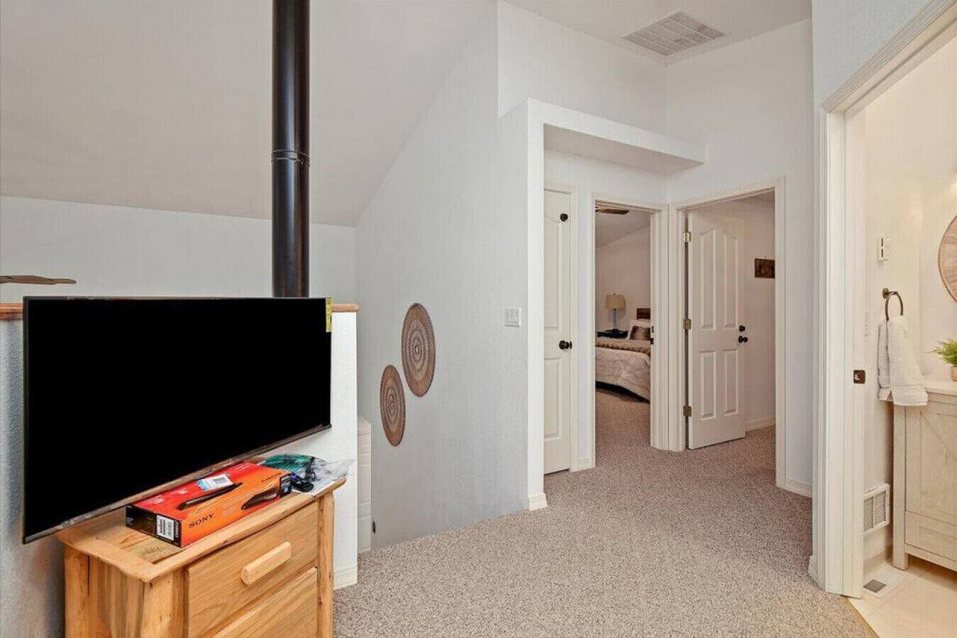 A bedroom with a bed, a bedside table, and a TV on a stand.