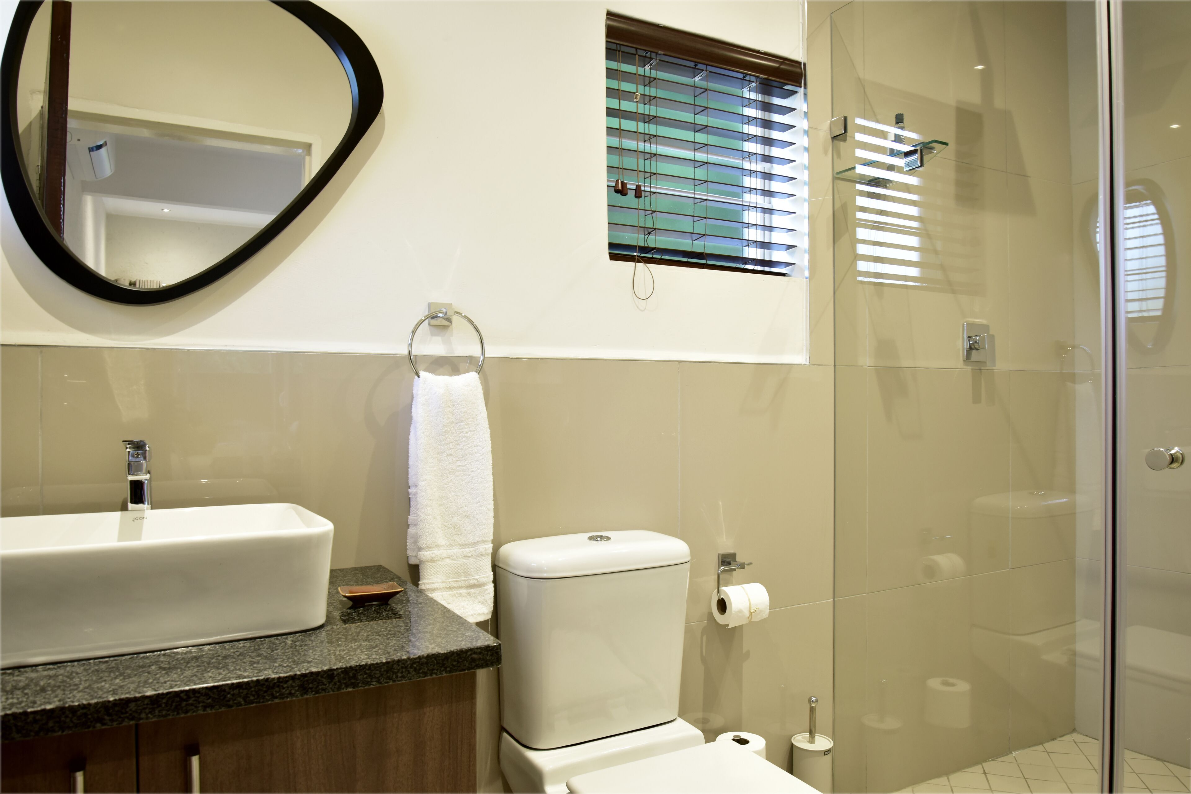 A bathroom with a sink, toilet, and shower.