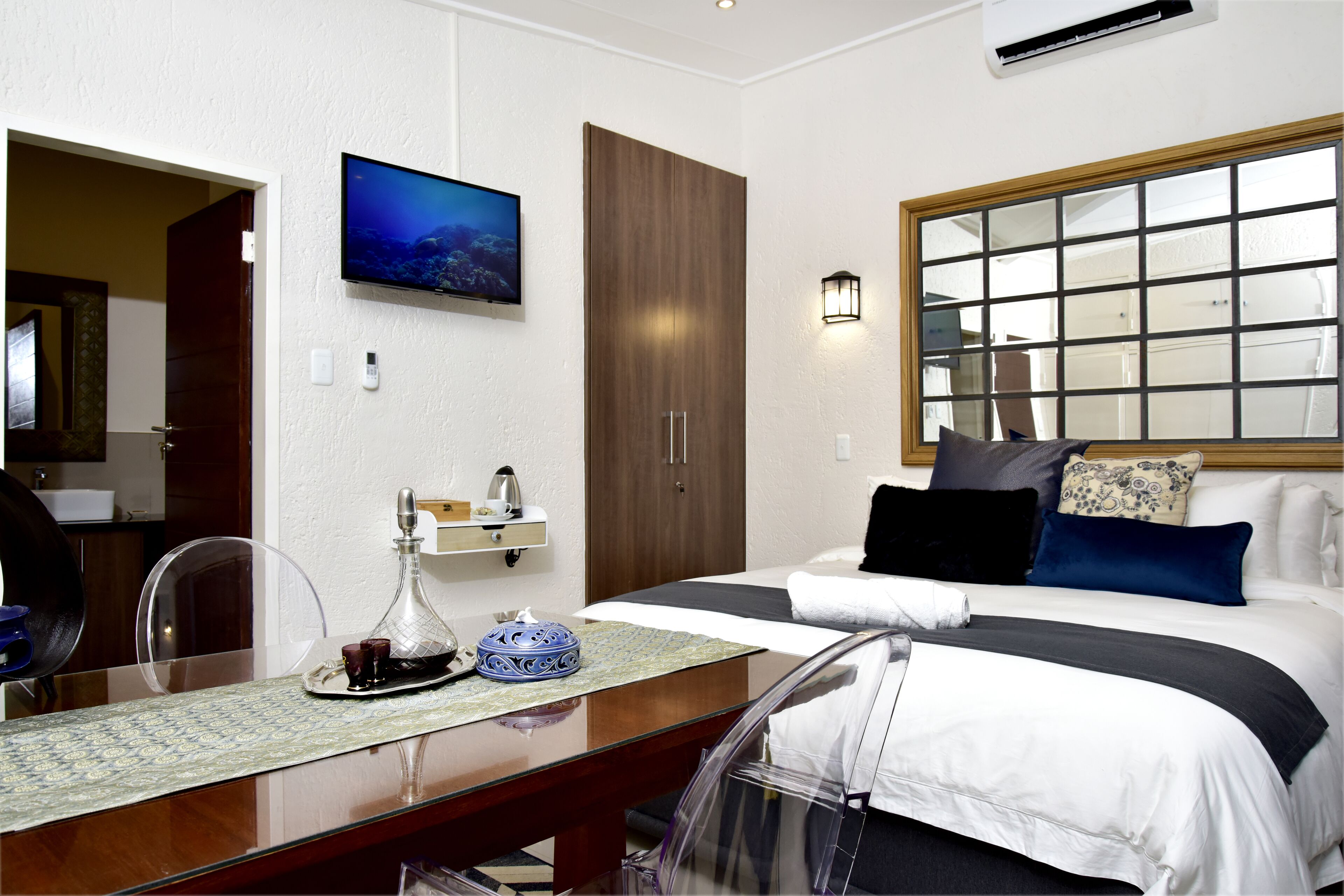 Une chambre d’hôtel équipée d’un lit, d’une table de chevet et d’un téléviseur fixé au mur.