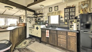 A kitchen with a vintage stove, modern sink, and a black refrigerator.