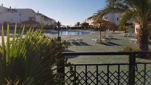 A pool area with lounge chairs, palm trees, and buildings in the background. - Naturist Baja house with courtyard in first line! (Vera)