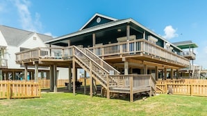 A multi-story building with a deck, stairs, and a fenced yard. - Starfish Beach Gem - Right ON Beach & So Lovely! (Surfside Beach)