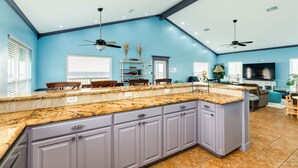 A kitchen with granite countertops, purple cabinets, and a large island. - Starfish Beach Gem - Right ON Beach & So Lovely! (Surfside Beach)