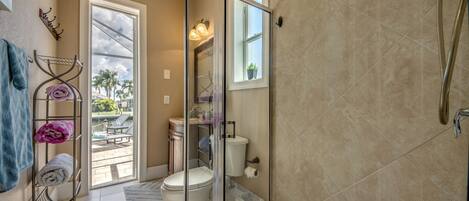 Un baño moderno con cabina de ducha de vidrio, inodoro y lavamanos.