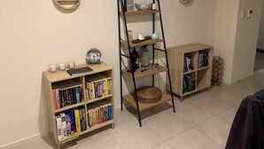 Ein Zimmer mit zwei hölzernen Bücherregalen, einem Hängeregál und runden Wandregalen.