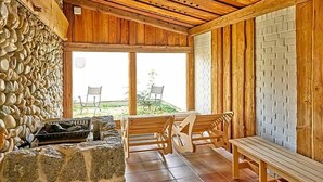 A wooden interior with stone walls, a bench, and a table. - Aquaquell Bad Pilzweg Hotel & Spa (Fuerstenzell)