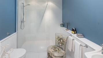 A bathroom with a shower, toilet, and sink.