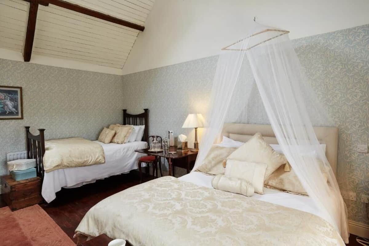 Un dormitorio con dos camas, una mesita de noche, una lámpara y un cuadro en la pared.