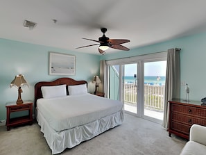 A bedroom with a bed, two bedside tables with lamps, a ceiling fan, a large window with a view of the beach, and a dresser. - Dory D | Stunning Location, Easy Beach Access + Pet Friendly (Perdido Key)