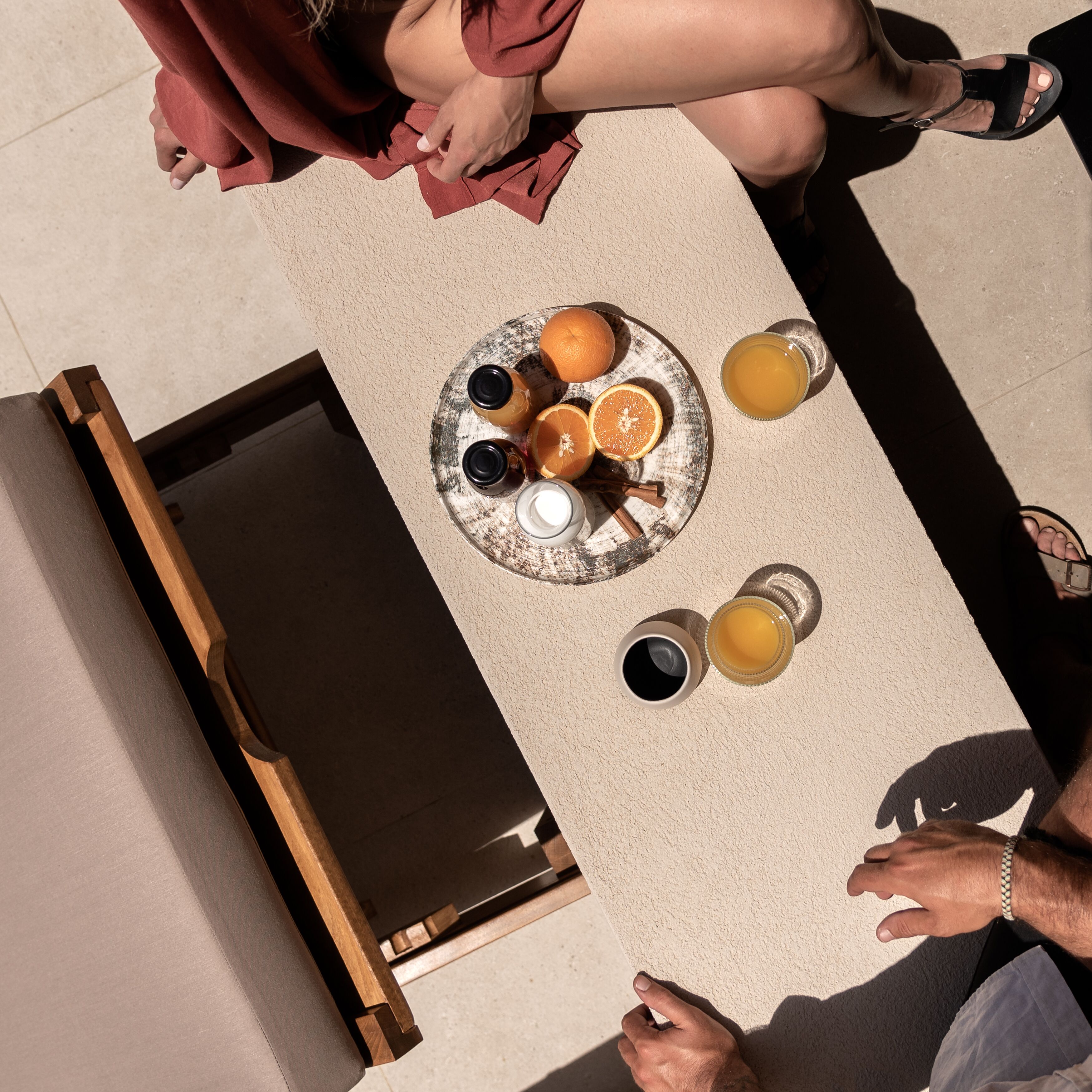 A breakfast setting with a plate of oranges, a glass of orange juice, and a cup of coffee on a table.