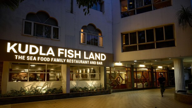 Exterior de Kudla Fish Land, un restaurante y bar de mariscos con fachada moderna y grandes ventanales.