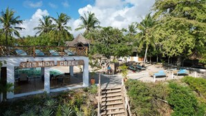 A resort named "The Mida Creek" with a wooden deck, lounge chairs, and palm trees. - The Mida Creek (Watamu)