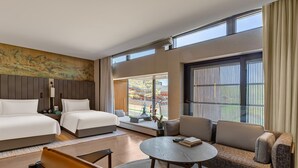 A hotel room with two beds, a sofa, a coffee table, and a large window with a view of the outdoors. - Yanbai Villa, Beijing (Huairou)