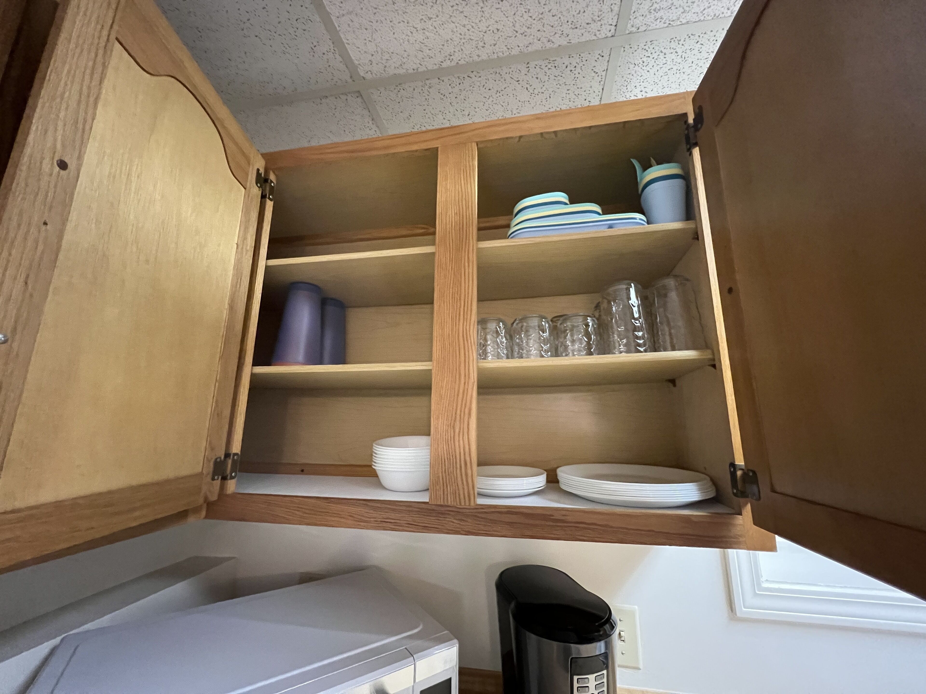 Una cocina con armarios de madera, microondas y cafetera.