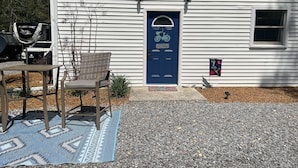 Une maison avec une porte bleue, un panneau d’accueil et une décoration en forme de bicyclette.