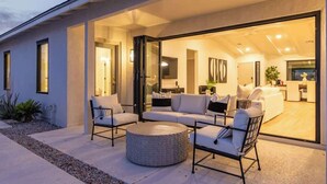An open-plan living area with a sofa set, a round coffee table, and a dining table. - The Kingsley|Custom|Heated Pool|Chef Kitchen|Chess (Scottsdale)