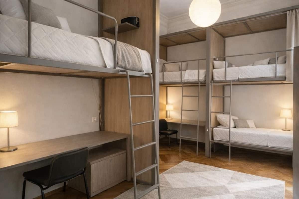 Ein kleines, modernes Zimmer mit Etagenbetten, einem Schreibtisch und einem Stuhl.