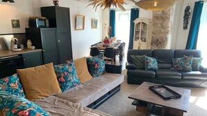 A living room with a sofa, a coffee table, and a dining area with a table and chairs.