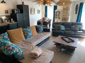 Una sala de estar con sofá, una mesa de centro y una zona de comedor con mesa y sillas.