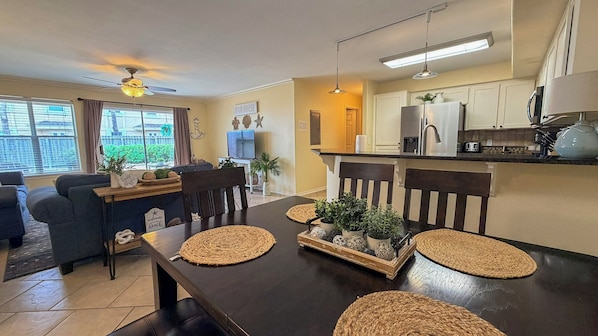 A dining area with a dark wooden table, woven placemats, and chairs.