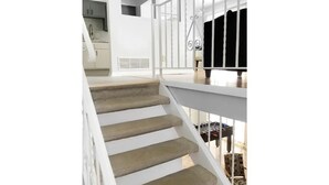 Una escalera con barandillas blancas que lleva a un balcón con vistas al interior.