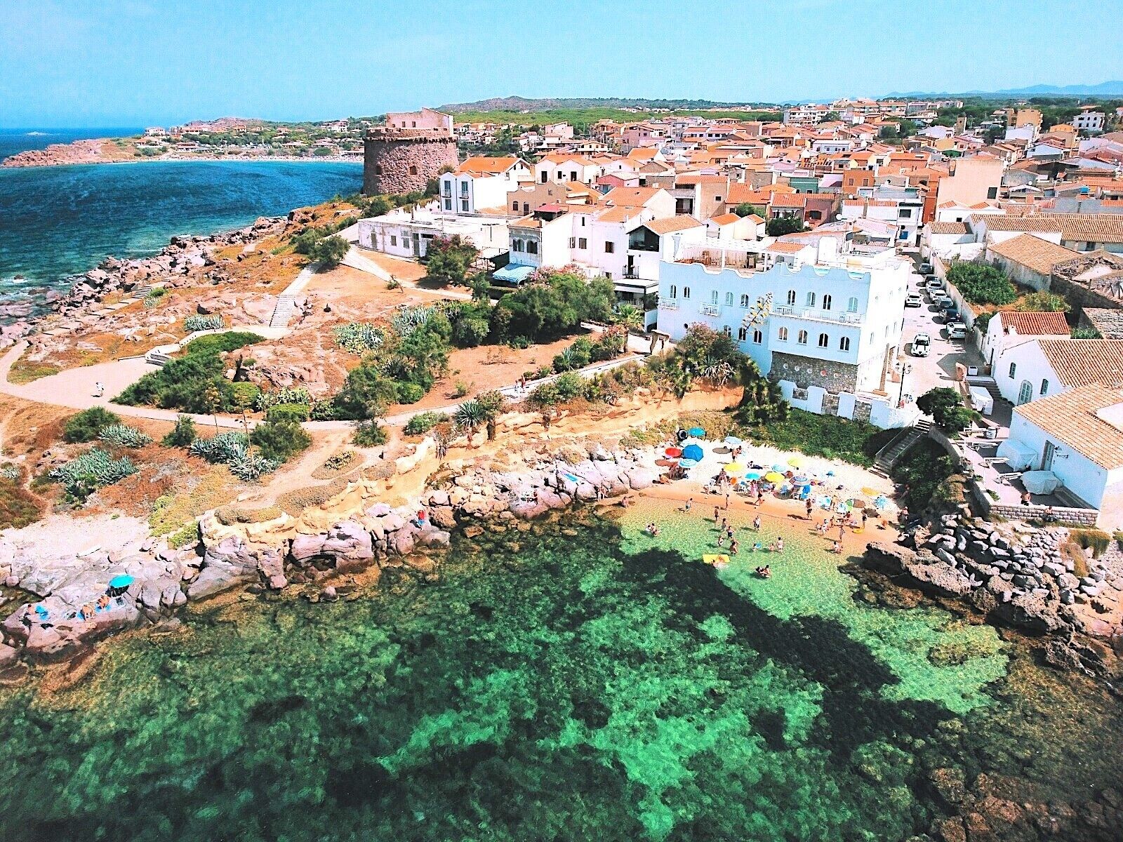 Una cittadina costiera con un'antica fortezza, acque limpide e una spiaggia attrezzata con ombrelloni.
