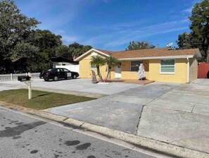 A single-story house with a yellow exterior, a front yard, and a mailbox.