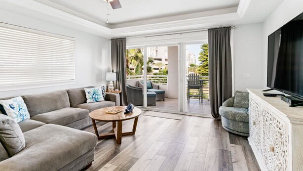 Ein geräumiges Wohnzimmer mit einer Couch, einem Couchtisch und einem Fernseher auf einer Holzkommode.