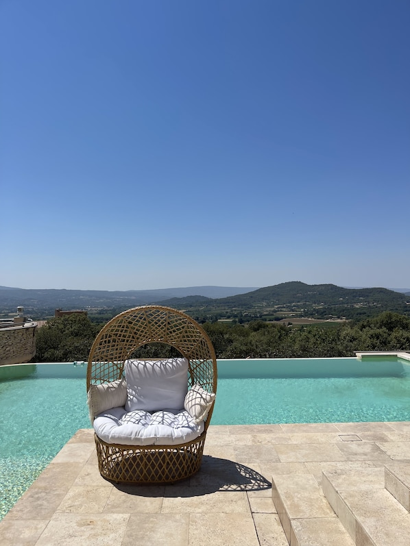 Een buitenzwembad en een infinitypool