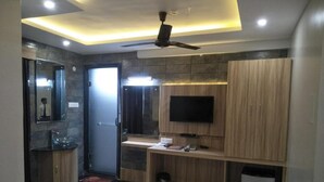 Un baño moderno con tocador, espejo y ventilador de techo.