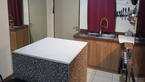 A compact kitchen with a sink, a small countertop, and a microwave. - Mucucu's place (Pasig)