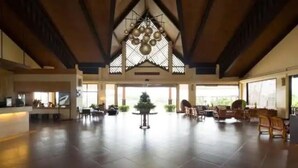 A spacious lobby with a high ceiling, a central Christmas tree, and a reception desk. - Central place  (Malay)