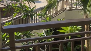 A balcony with a view of a beach, palm trees, and a pool. - Central place  (Malay)