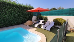 A backyard with a swimming pool, lounge chairs, and a red umbrella. - Large Villa for 10 people in a sought-after area of Marseille (Marseille)