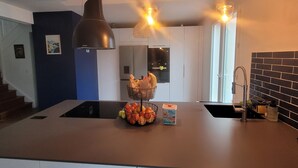 A modern kitchen with a central island, two pendant lights, a built-in oven, and a black tiled backsplash. - Large Villa for 10 people in a sought-after area of Marseille (Marseille)