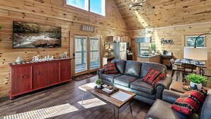 A spacious log cabin interior with a living room, dining area, and kitchen. - Award winner| Dollywood |Arcades|Hot tub |GSMNP (Sevierville)