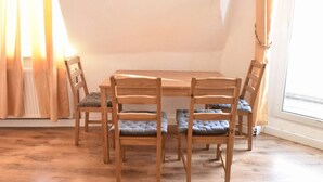 A room with a wooden table and four chairs with cushioned seats.