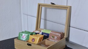 A wooden box with compartments containing various food items.