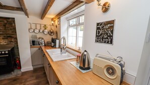 A kitchen with wooden countertops, a vintage radio, and a sign saying "Eat Drink It's the HAPPY".