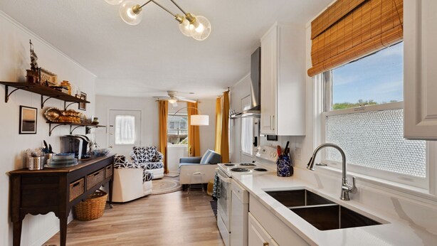 A modern kitchen with white cabinets, a stainless steel sink, and a window with a view. - 5041 The Captains Quarters *1 Block to Boat Access (Kill Devil Hills)