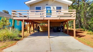 A two-story building with a covered parking area and a sign indicating it is a vacation rental. - 5041 The Captains Quarters *1 Block to Boat Access (Kill Devil Hills)