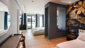 Ein modernes Hotelzimmer mit einem großen Bett, einer Sitzecke mit einem Sessel, einem kleinen Tisch und einem großen Fenster mit Blick auf die Stadt.