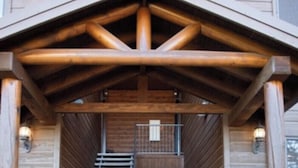 Een houten gebouw met een trap die leidt naar een balkon op de tweede verdieping.
