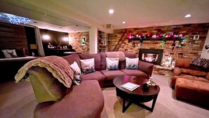 Una sala de estar acogedora con un sofá modular, una mesa de centro y una chimenea.
