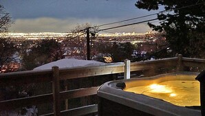 Un jacuzzi con barandilla de madera, rodeado de nieve.